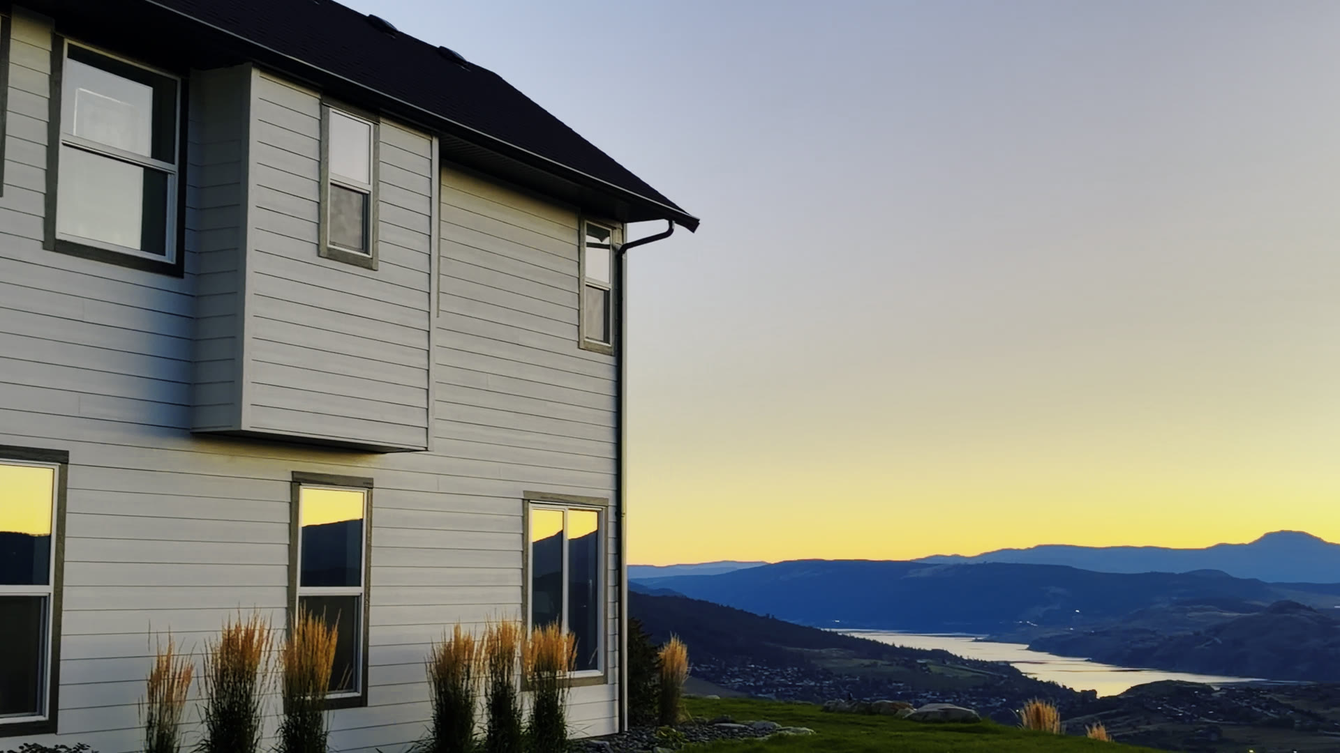 Corner of the house with Kalamalka Lake below at sunset