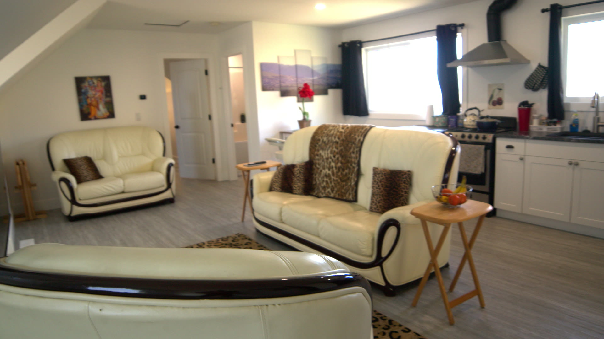 Living room: all three leather couches with the kitchen behind