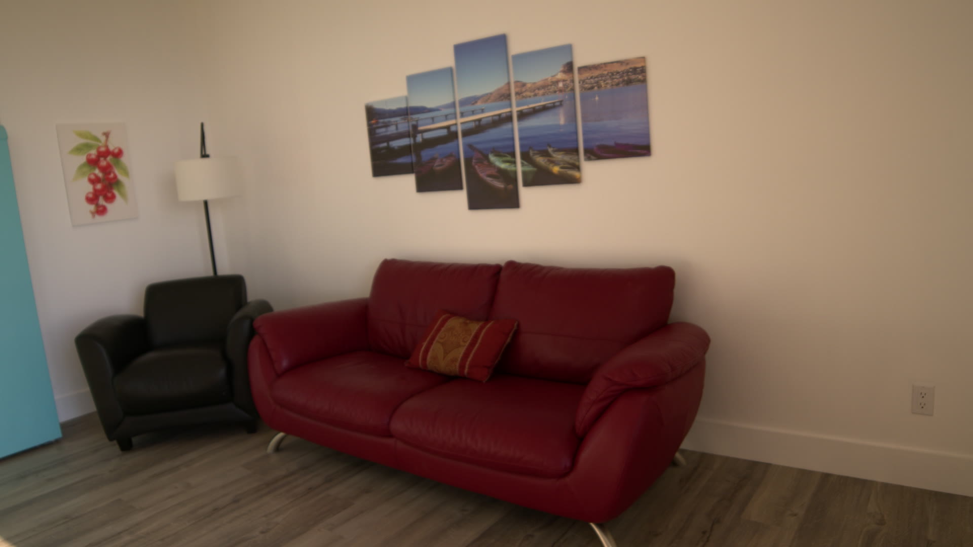 Living room: red leather sofa and armchair under the canvas prints of the lake