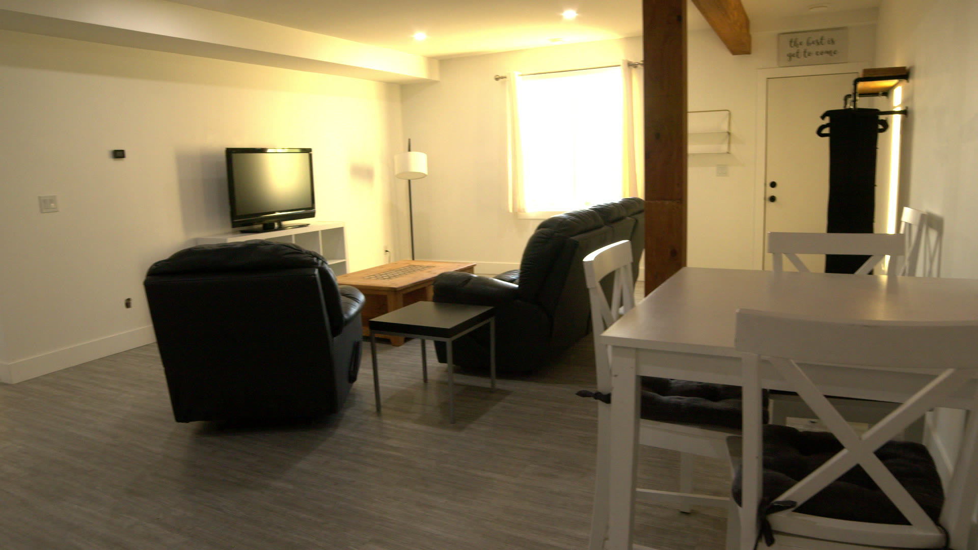 Living room: two leather recliners, the TV, the window and the table by the timber post